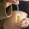 Mother Mother Everything Oil (1 oz) - product shown being opened by model. 