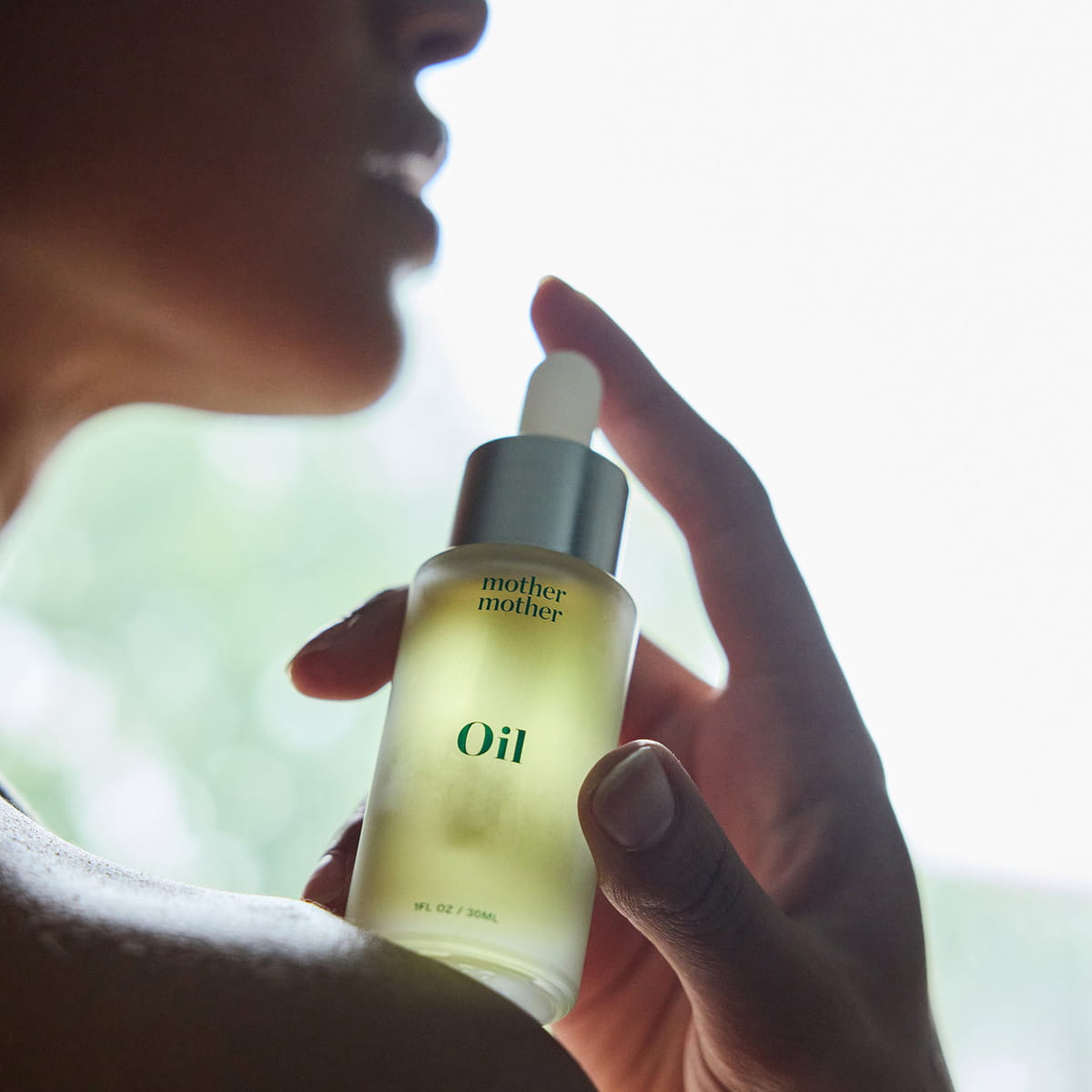 Mother Mother Everything Oil (1 oz) - product shown being held by model. 