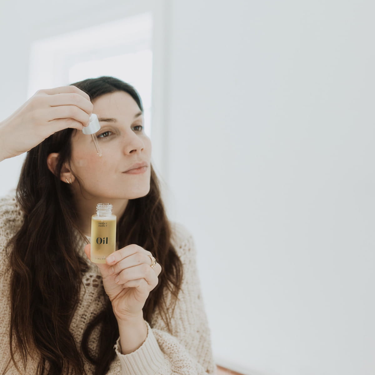 Mother Mother Everything Oil (1 oz) - product shown being applied to model's face. 