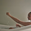 Mother Mother Soak (12 oz) - product show being poured into bathtub. 
