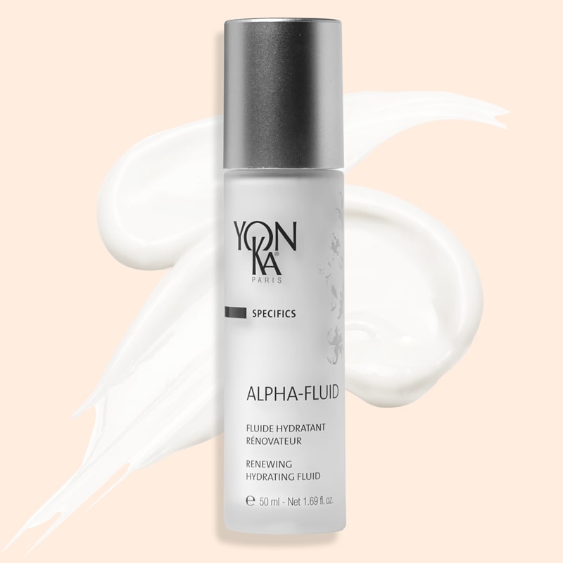 Yon-Ka Paris Alpha Fluid (50 ml) shown top view with product smear in the background to show color and texture