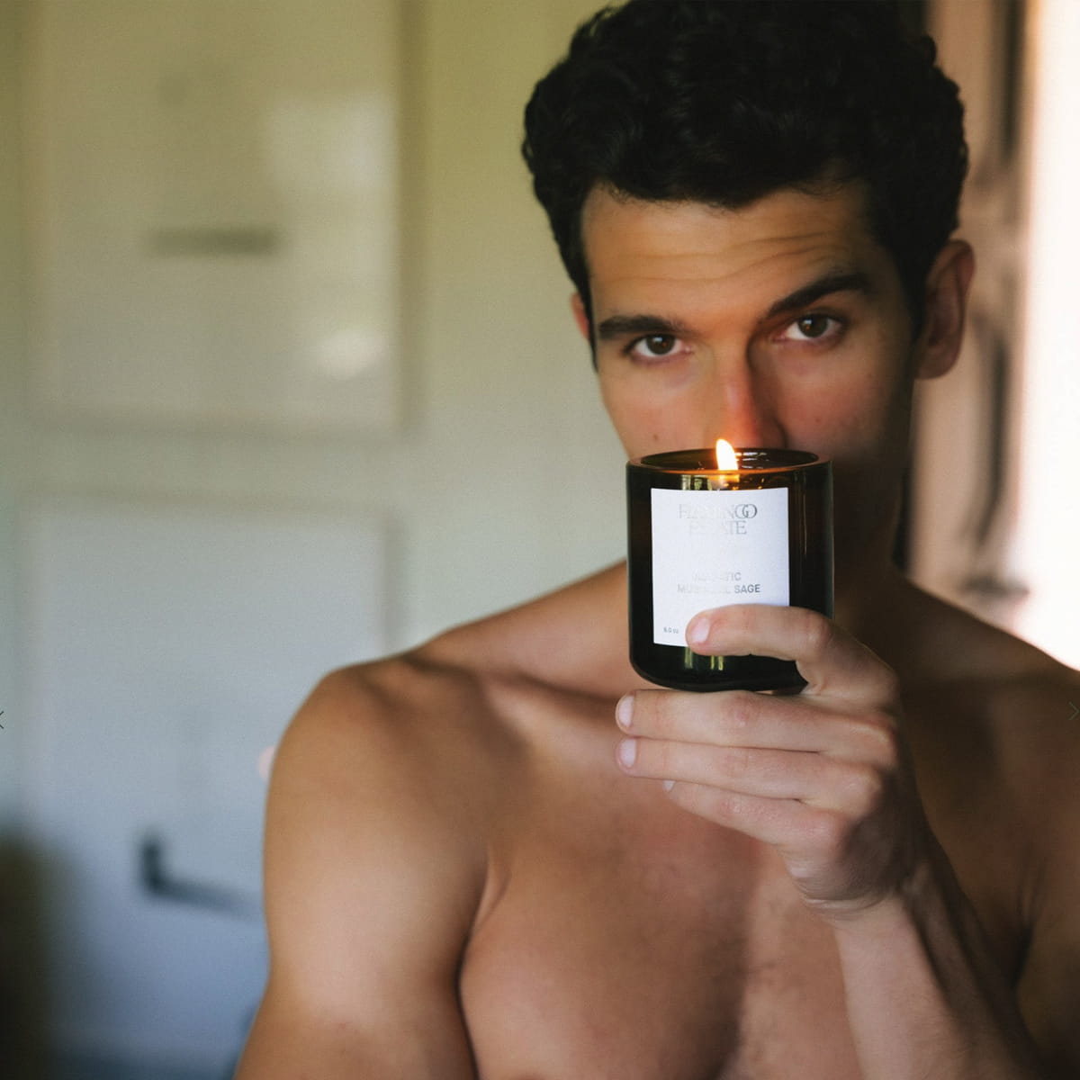 Flamingo Estate Adriatic Muscatel Sage Candle (226 g) - product shown lit being held by model. 