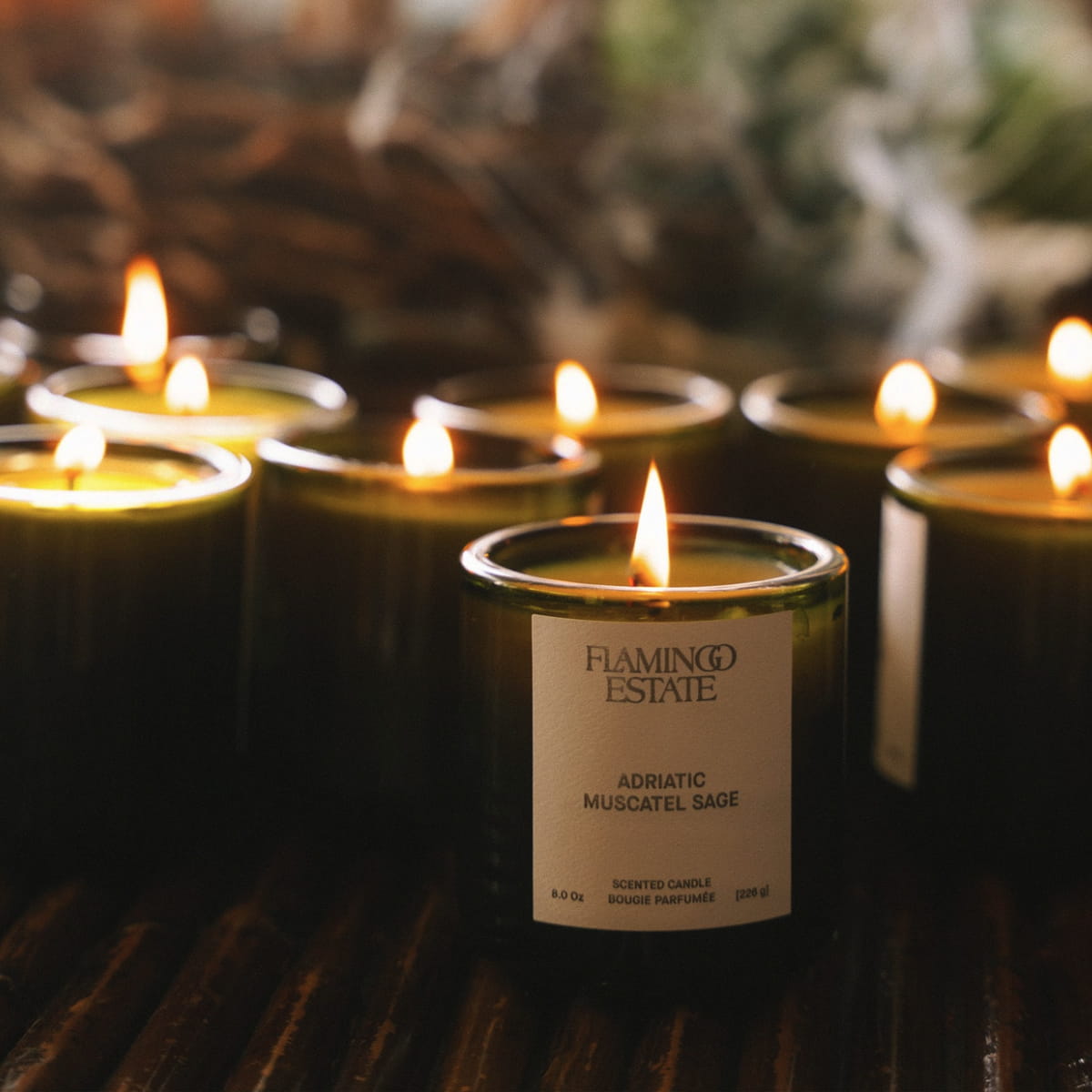 Flamingo Estate Adriatic Muscatel Sage Candle (226 g) - product shown lit in front of lots of other candles.