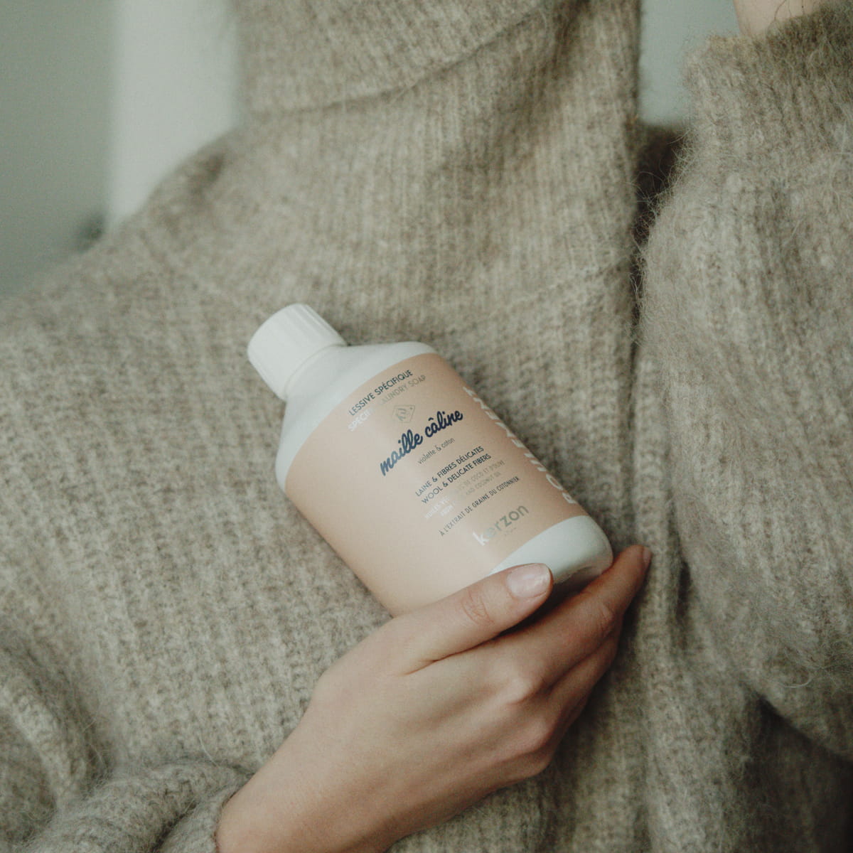 Kerzon Laundry Soap - Maille Caline (500 ml) - product shown being held by model in wool sweater. 