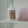Kerzon Laundry Soap - Maille Caline (500 ml) - product shown next to folded pink wool sweater. 