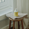 Kerzon Laundry Soap - Gym Tonique (500 ml) - product shown on top of stool and towel. 