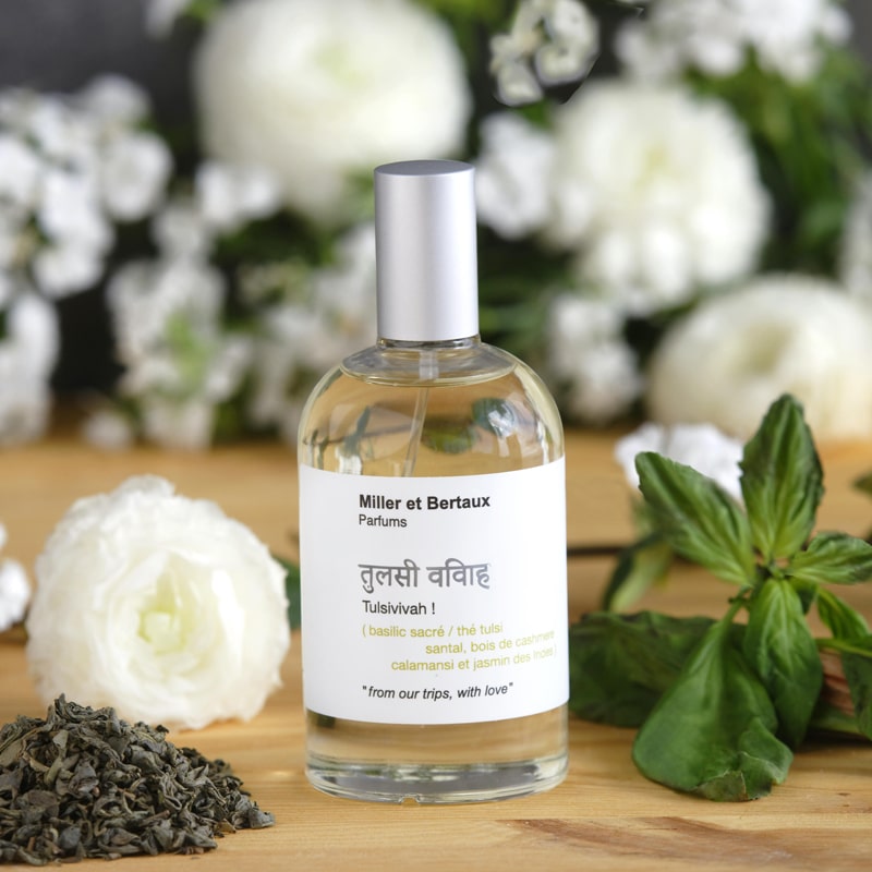 Miller et Bertaux Tulsivivah Eau de Parfum (100 ml) lifestyle shot with ingredients, and white flowers in the background