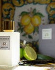 Lifestyle shot of Morn to Dusk Eau de Parfum Spray (100 ml) with box, vanilla pods and limes in the background