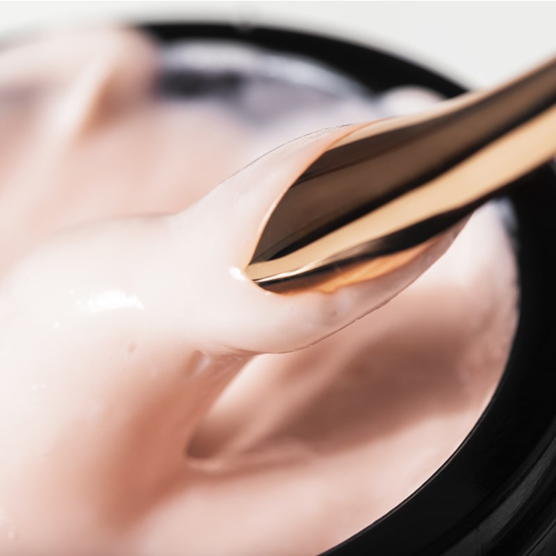Close up of Odacite Creme de la Nuit shown open with spatula dipped in cream
