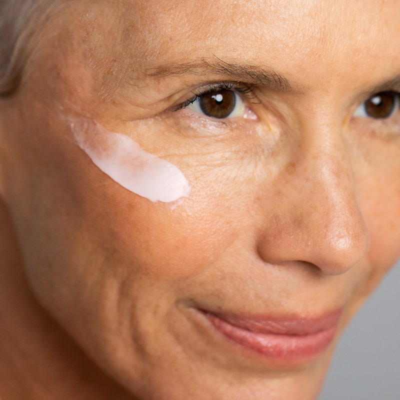Close up of Odacite Creme de la Nuit applied to woman&#39;s face with mature skin