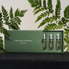 Lifestyle shot of Laboratory Perfumes Lifestyle Set (5 x 5 ml) with box slightly open and ferns in the background