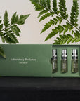 Lifestyle shot of Laboratory Perfumes Lifestyle Set (5 x 5 ml) with box slightly open and ferns in the background