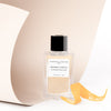 Essential Parfums Orange X Santal Perfume by Natalie Gracia Cetto - Refillable - product shown next to orange peel.