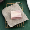 Fog Linen Work Linen Knit Wash Cloth pictured with bar of soap (soap not included) on green background