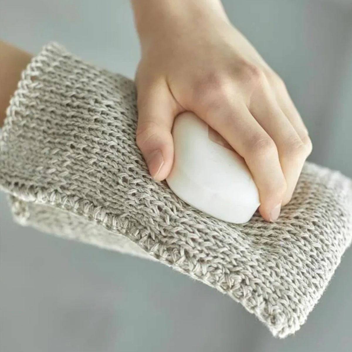 Model using Fog Linen Work Linen Knit Wash Cloth with bar of soap (soap not included)