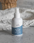 Lifestyle shot of Earth Mama Organics Perineal Spray (4 oz) with cloth in the background