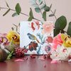 Storytiles Small Tile – Nathalie Lete Feeling Floral (1 pc) - product shown surrounded by leaves and flowers. 
