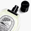 Diptyque Eau Moheli Eau de Toilette (100 ml) - product shown laying on counter with lid off. 