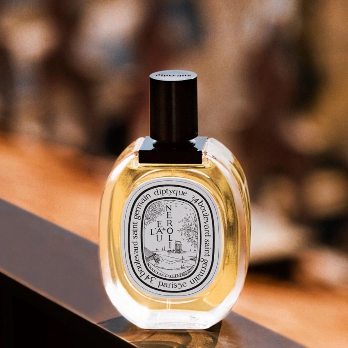 Diptyque L'Eau de Neroli Eau de Toilette (100 ml)- product shown on wooden railing.