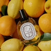 Diptyque L’Eau des Hesperides Eau de Toilette (100 ml) - product shown on top of pile of lemons. 