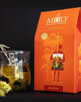 Lifestyle shot of Moly The Mythic Antidote Digestion Organic Herbal Tea with tea in glass cup and box of Digestion tea