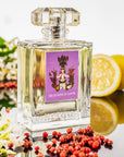 Lifestyle shot of Carthusia Gelsomini di Capri Eau de Parfum (100 ml) with lemons and flowers in the background and rose pepper in the foreground