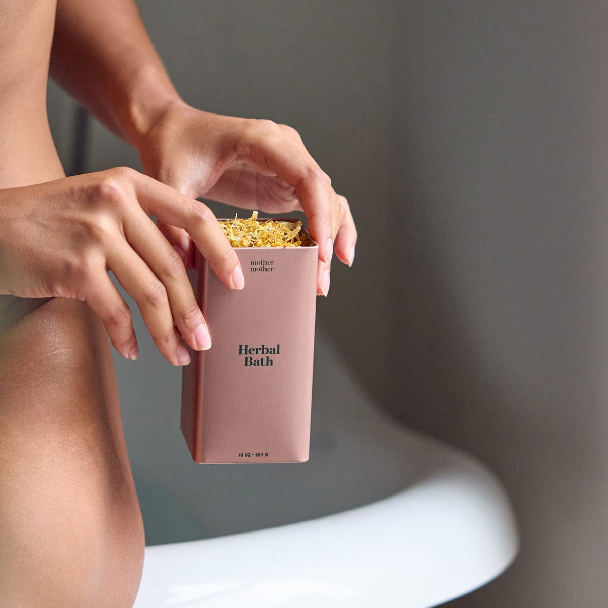 Mother Mother Organic Herbal Bath (10 oz) - product shown being held by model. 