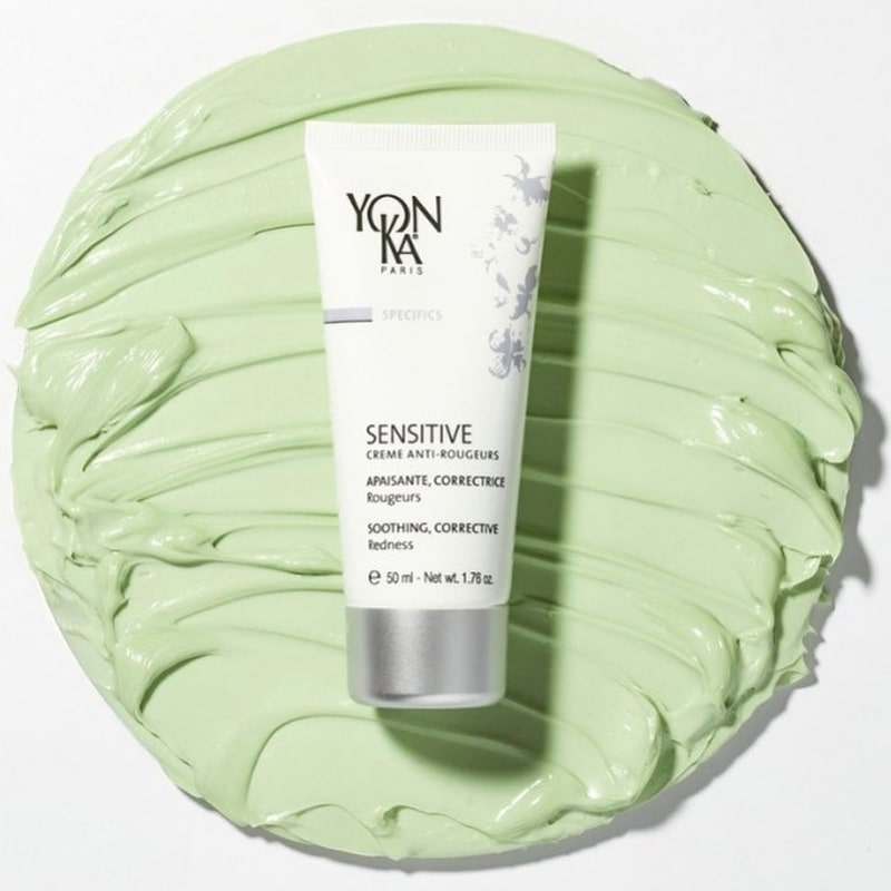 Top view of Yon-Ka Paris Sensitive Creme Anti-Redness (50 ml) with large smear of product in the background to show green color and texture