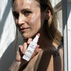 Odacite SPF 50 Sheer Sunscreen Mineral Drops (30 ml) - product shown being held by model. 