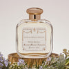 Lifestyle shot of Santa Maria Novella Acqua Della Regina Eau de Cologne (100 ml) with flowers in the foreground