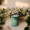 Kerzon Fragranced Candle - La Tour Eiffel (190 g) - product shown in front of flowers.