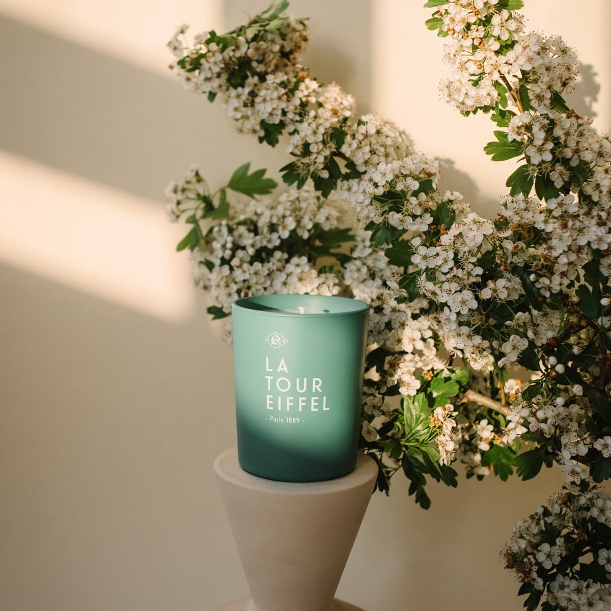 Kerzon Fragranced Candle - La Tour Eiffel (190 g) - product shown in front of flowers.