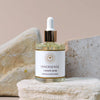 Lifestyle shot of Innersense I Create Shine (1.69 oz) sitting on stone with stones in the background