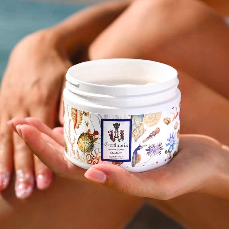Model holding jar of Carthusia A’mmare Body Lotion (250 ml) with lid off in palm of her hand