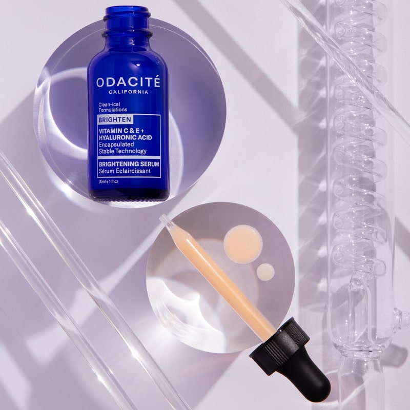 Lifestyle shot of Odacite Vitamin C &amp; E + Hyaluronic Acid Brightening Serum bottle with dropper