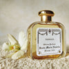 Lifestyle shot of Santa Maria Novella Vaniglia Eau de Cologne (100 ml)  with flower beside bottle