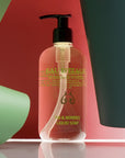 Lifestyle shot of Eau d'Italie Fig & Berries Liquid Soap (300 ml) with red and green paper in the background