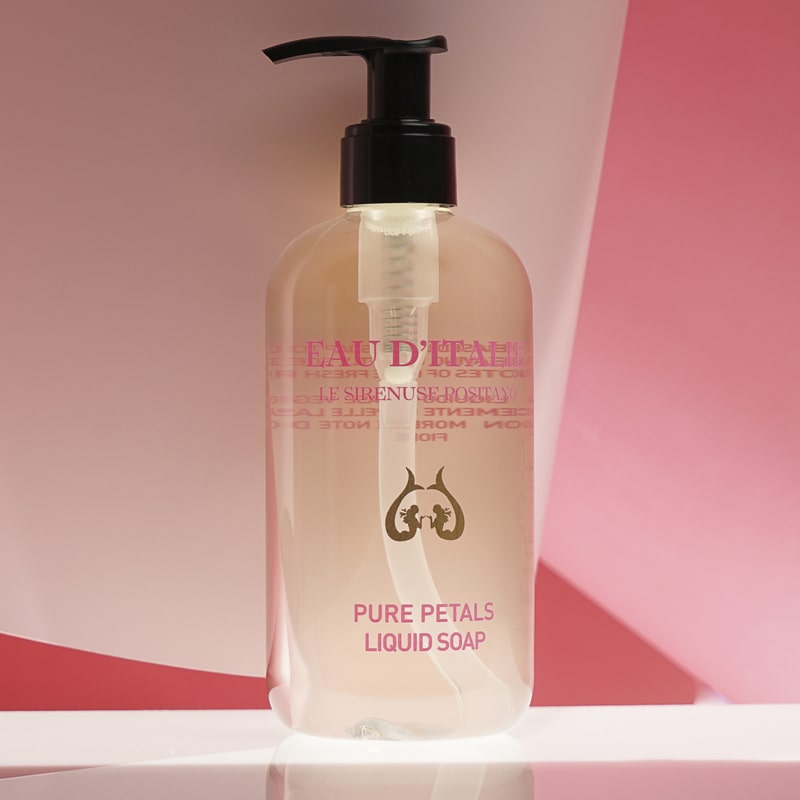 Lifestyle shot of Eau d&#39;Italie Pure Petals Liquid Soap (300 ml) with red and pink paper in the background