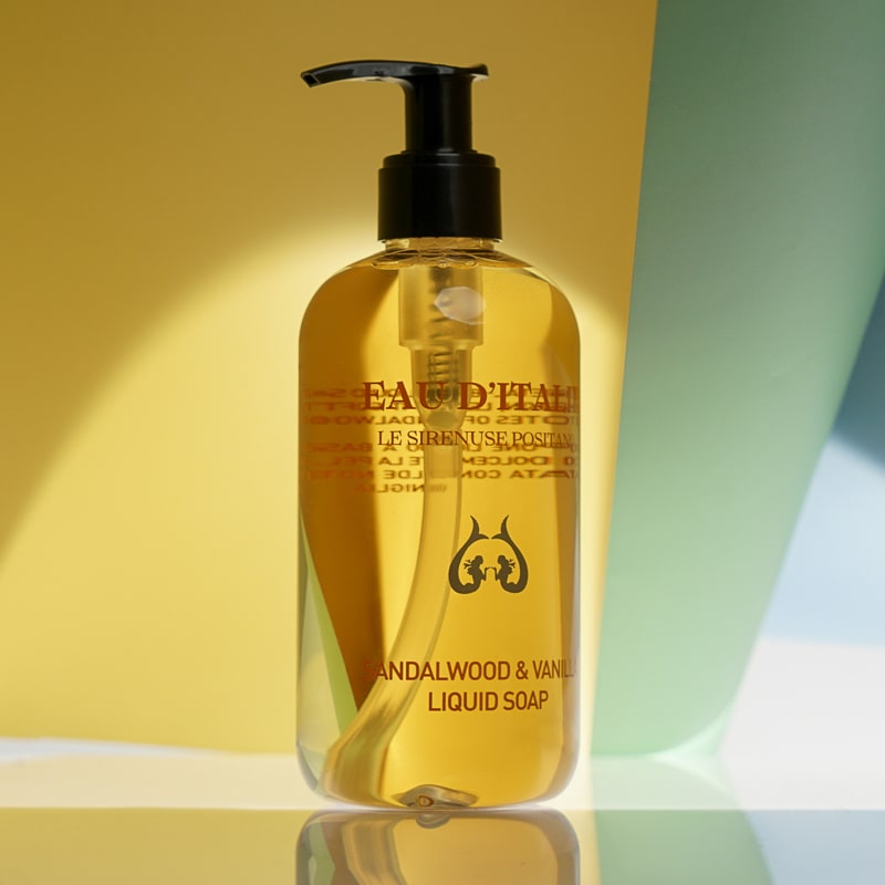 Lifestyle shot of Eau d&#39;Italie Sandalwood &amp; Vanilla Liquid Soap (300 ml) with yellow and green paper in the background