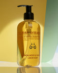 Lifestyle shot of Eau d'Italie Sandalwood & Vanilla Liquid Soap (300 ml) with yellow and green paper in the background