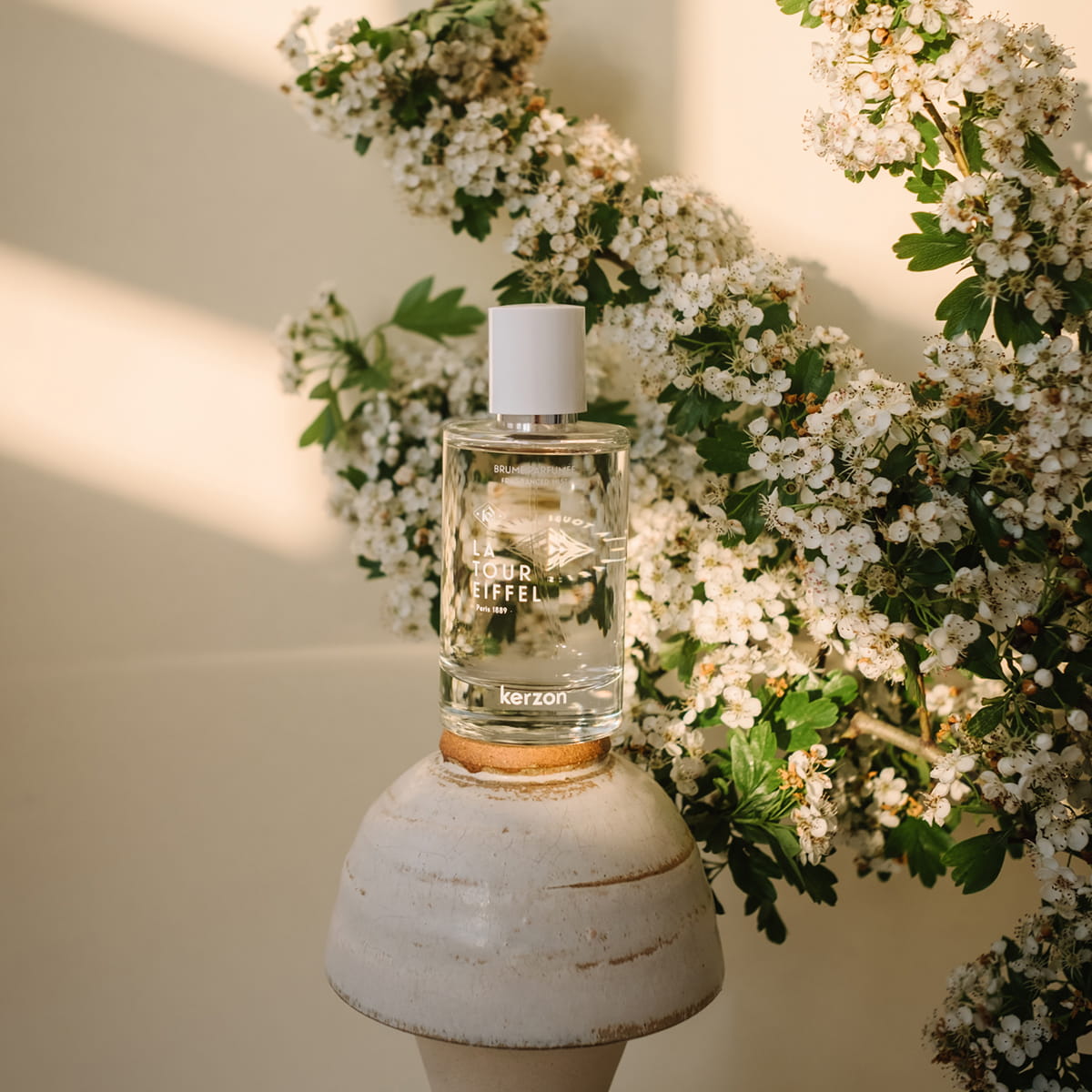 Kerzon Fragranced Mist - La Tour Eiffel (100 ml) - product shown on white flowers on top of pot. 