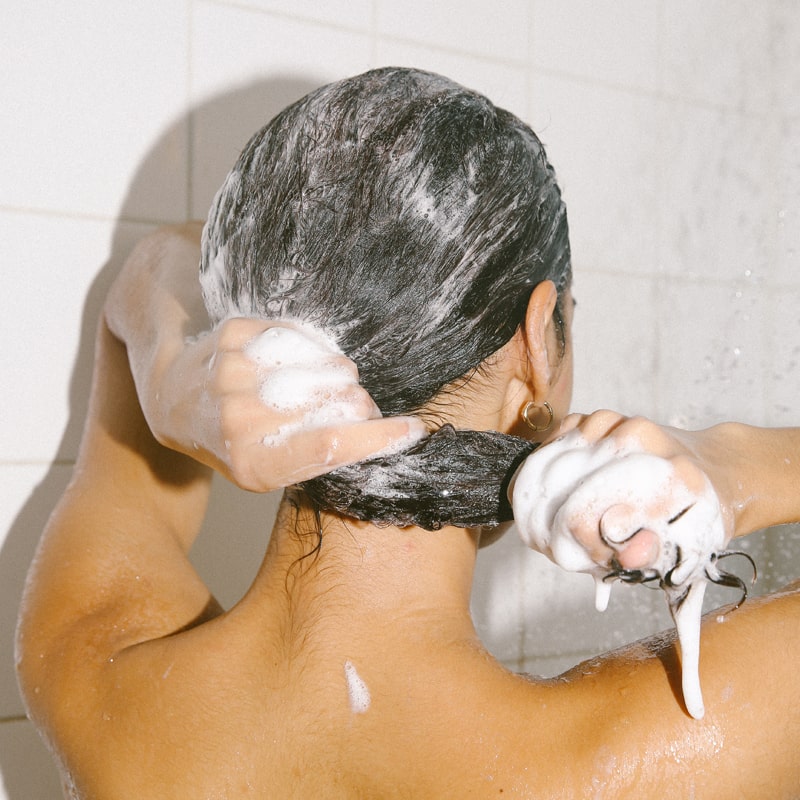 Lifestyle shot of model lathering in hair Bathing Culture Kelp Forest Shampoo - Break Water