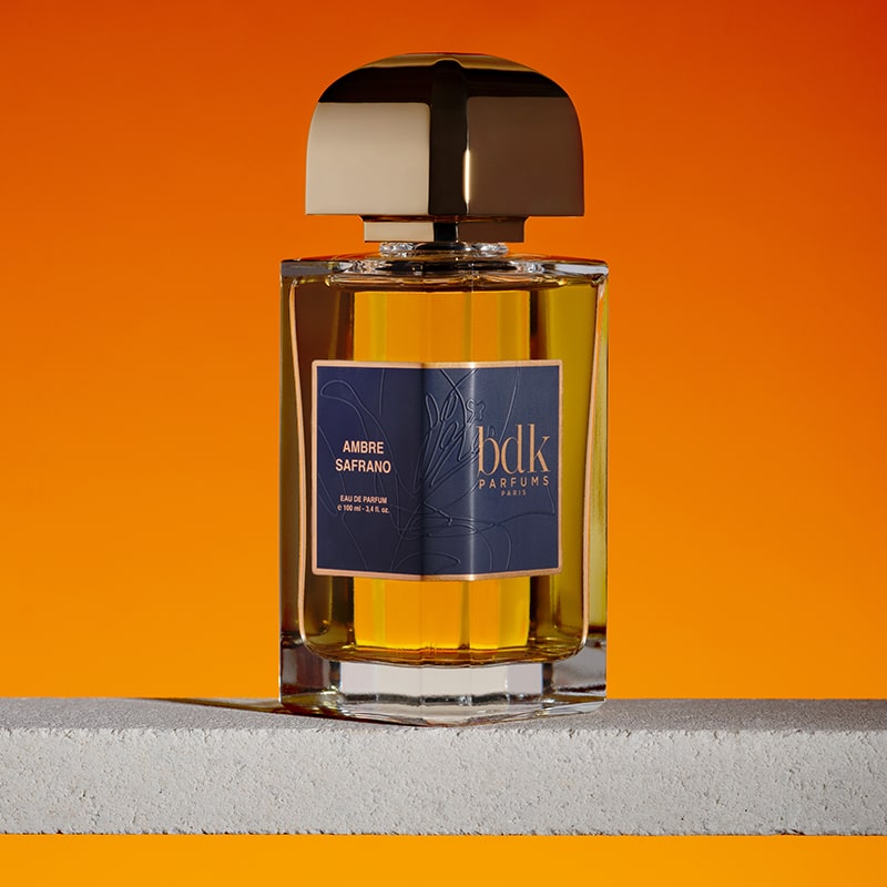 BDK Parfums Ambre Safrano Eau de Parfum - bottle sitting on stone slab on orange background