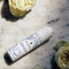 Lifestyle shot of Santa Maria Novella Idralia Serum (30 ml) with white roses in the background