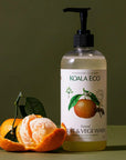 Lifestyle shot of Koala Eco Natural Fruit and Vege Wash - Mandarin (16.9 oz) with mandarin peeled in the foreground