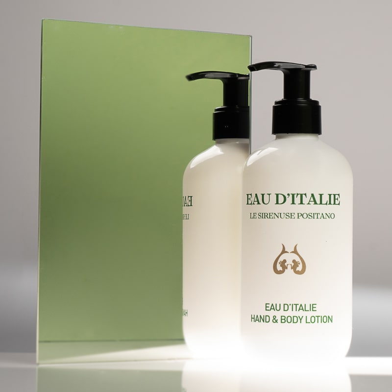 Lifestyle shot of Eau d&#39;Italie Signature Scent Hand &amp; Body Lotion (300 ml) in front of mirror with green background reflection
