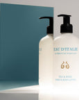 Lifestyle shot of Eau d’Italie Tea & Rose Hand & Body Lotion (300 ml) in front of mirror with blue background reflection
