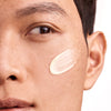 Augustinus Bader The Retinol Serum (30 ml)  - model shown with product swatch on face