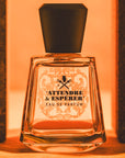 Lifestyle shot of Frapin Attendre & Esperer Eau de Parfum with bricks on either side of the bottle and bright orange background