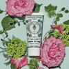 Lifestyle shot of Santa Maria Novella Acqua di Rose Cleansing Gel (100 ml) with pink roses and leaves in the background